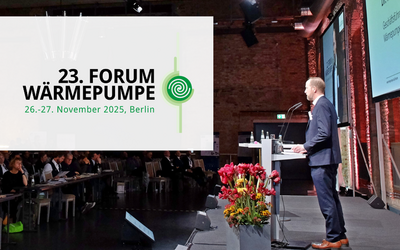 Ein Redner steht an einem Podium während des 23. Forums Wärmepumpe in Berlin. Im Hintergrund sind zahlreiche Zuschauer zu sehen. Auf der Leinwand ist das Event-Logo mit Datum und Ort eingeblendet. Frische Blumen stehen auf dem Tisch.