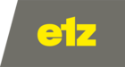 Logo der Marke "etz" in gelber Schrift auf grauem Hintergrund. Die Buchstaben sind modern und klar gestaltet.