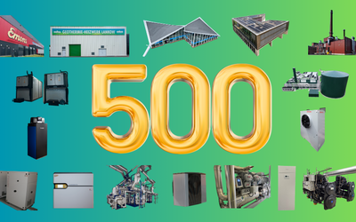 Zahl 500 in großen goldenen Ziffern vor einem farbverlaufenden Hintergrund. Um die Zahl herum sind verschiedene industrielle Maschinen und Gebäude angeordnet, darunter Heizsysteme und geothermische Anlagen.